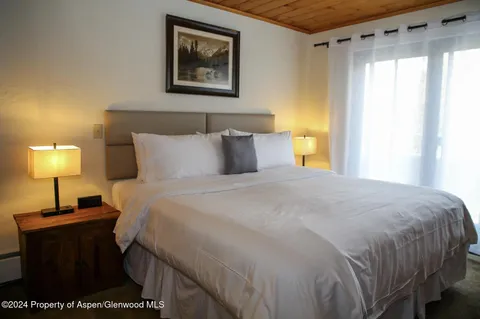 a bedroom with a bed and a lamp on table