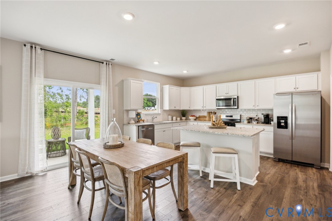 211 Happy Valley Road Keswick, VA 22947 - Photo 9 of 31 a kitchen with a table chairs refrigerator and cabinets