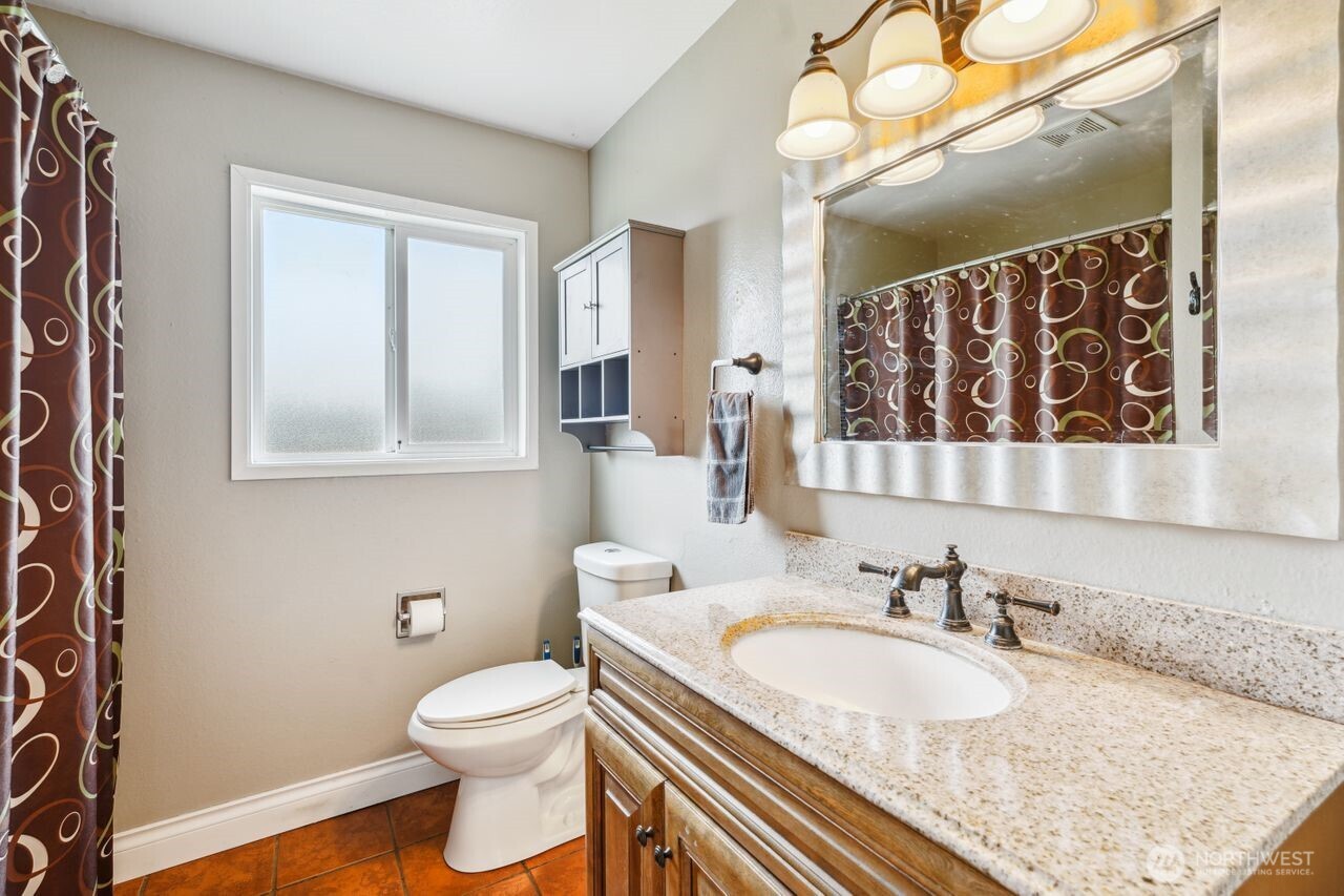3381 Nebraska Street Longview, WA 98632 - Photo 11 of 25 a bathroom with a granite countertop sink vanity mirror and toilet