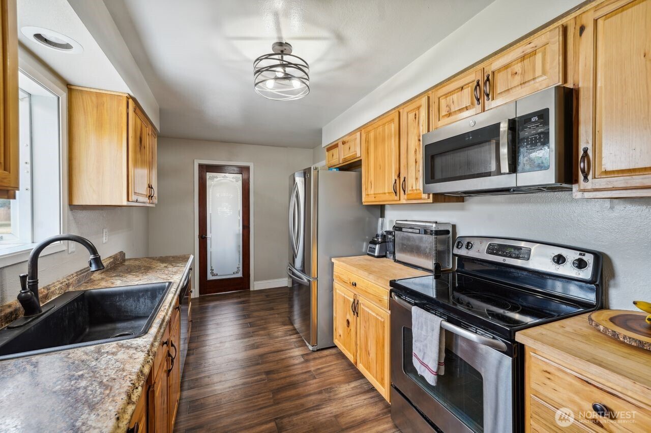 3381 Nebraska Street Longview, WA 98632 - Photo 13 of 25 a kitchen with stainless steel appliances a stove sink microwave and cabinets
