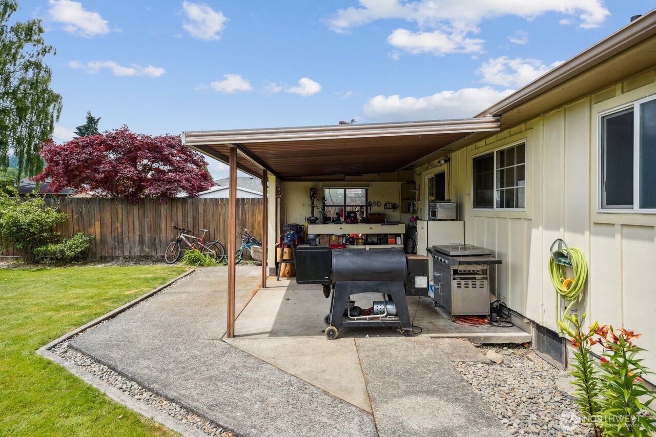 3381 Nebraska Street Longview, WA 98632 - Photo 21 of 25 a view of a patio with table and chairs a barbeque with potted plants and wooden fence