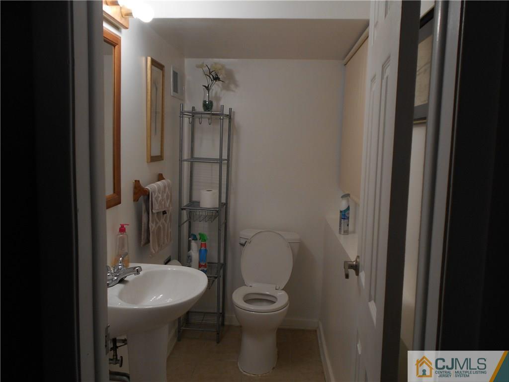17 Kingsbridge Road Somerset, NJ 08873 - Photo 5 of 11 a bathroom with a toilet a sink and mirror