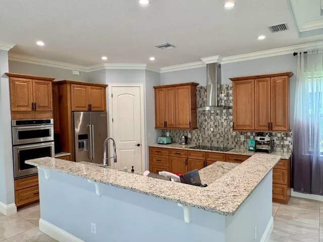 a kitchen with stainless steel appliances granite countertop sink stove and refrigerator
