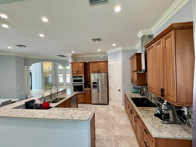a kitchen with stainless steel appliances granite countertop a sink stove and refrigerator
