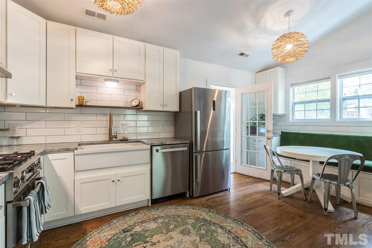 1024 Mills Street Raleigh, NC 27608 - Photo 11 of 30 a kitchen with stainless steel appliances granite countertop a refrigerator a sink dishwasher a stove a dining table and chairs with wooden floor