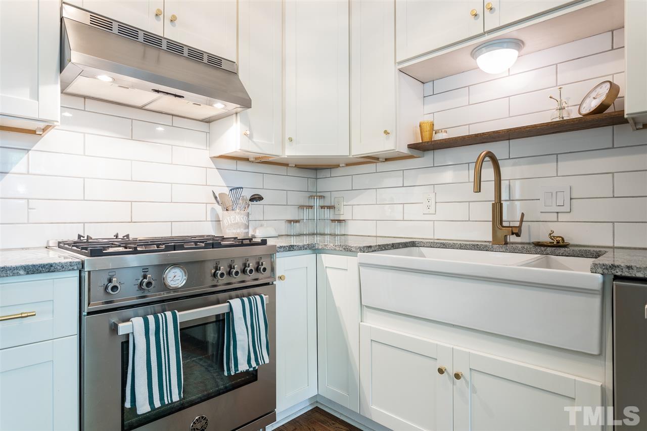 1024 Mills Street Raleigh, NC 27608 - Photo 12 of 30 a kitchen with granite countertop a stove sink and cabinets