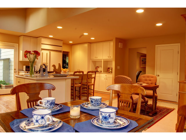 3059 Aztec Road Pebble Beach, CA 93953 - Photo 9 of 24 a living room with dining table a couches with kitchen view and a wooden floor