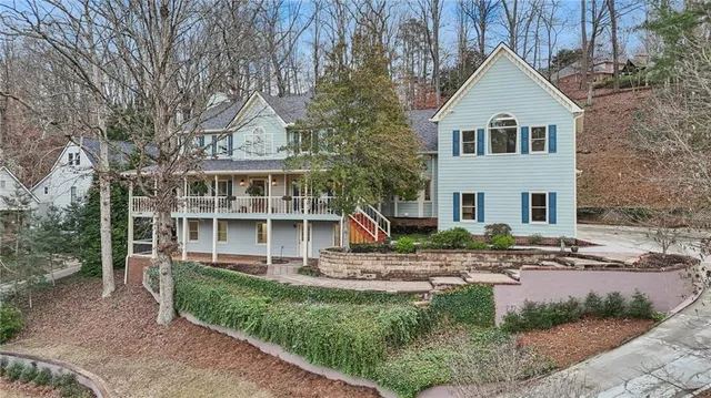 a view of a house with a yard and large tree