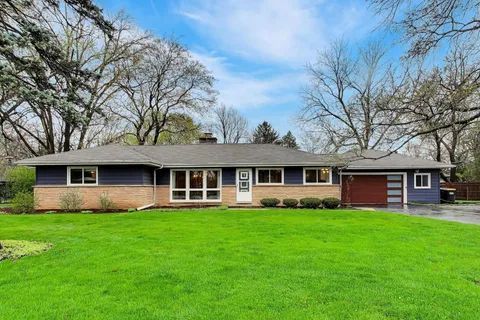 a front view of a house with a yard and trees