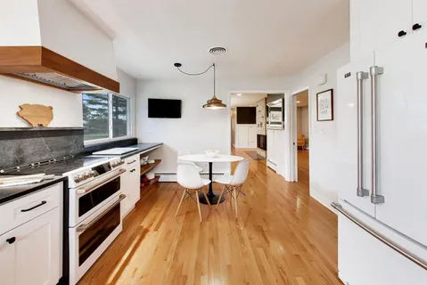 a large kitchen with stainless steel appliances granite countertop a lot of counter space and wooden floor