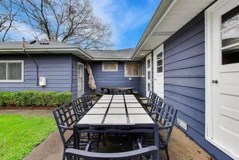 a view of a patio with a table chairs and wooden fence