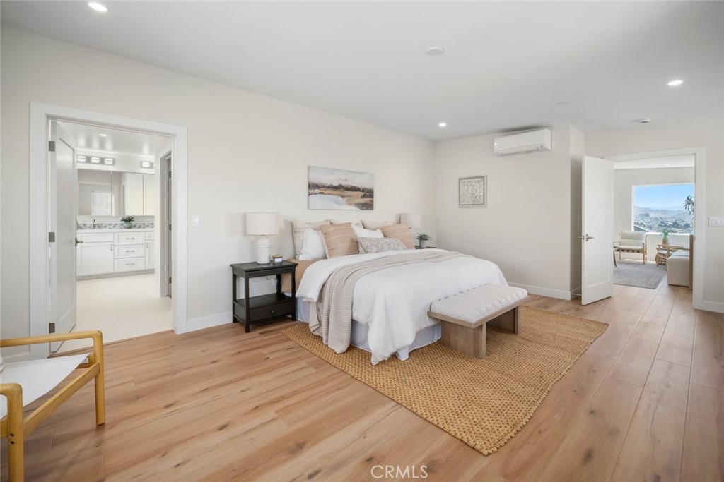 548 Blanca Street Morro Bay, CA 93442 - Photo 21 of 50 a spacious bedroom with a bed and wooden floor
