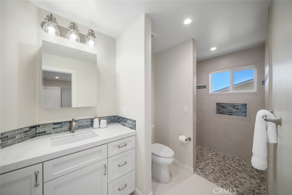 548 Blanca Street Morro Bay, CA 93442 - Photo 29 of 50 a bathroom with a sink a toilet and a mirror