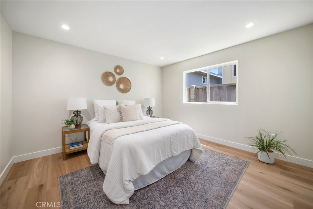 548 Blanca Street Morro Bay, CA 93442 - Photo 38 of 50 a bedroom with a large bed and a potted plant