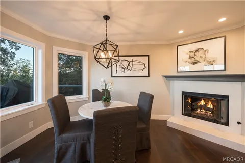 a dining room with furniture a fireplace and wooden floor