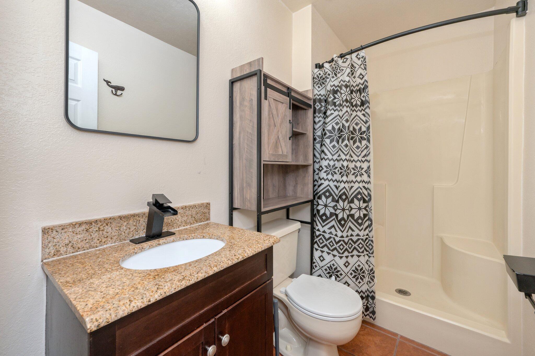 5369 Pecos Pass Gulf Breeze, FL 32563 - Photo 6 of 26 a bathroom with a granite countertop sink toilet and shower