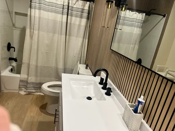 a bathroom with a sink a toilet and shower