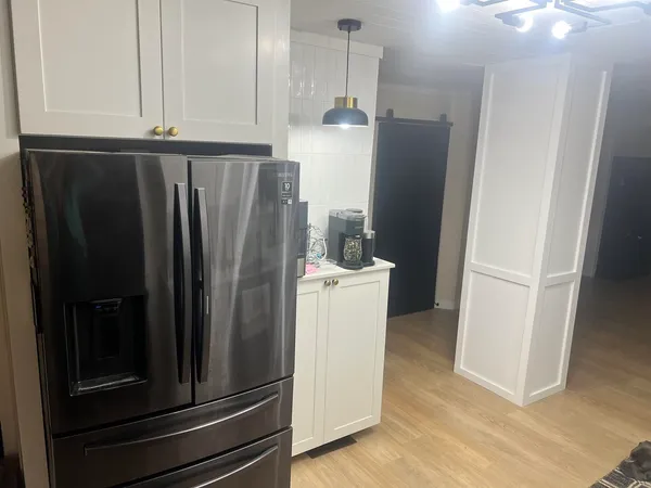 a view of a kitchen with refrigerator and cabinet