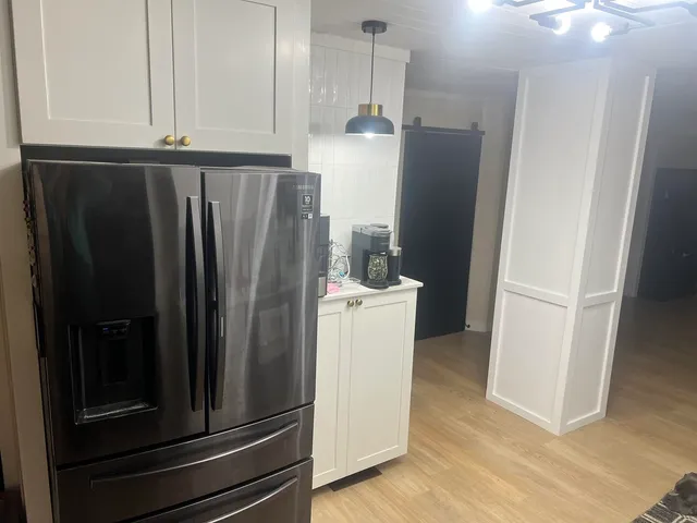 a view of a kitchen with refrigerator and cabinet