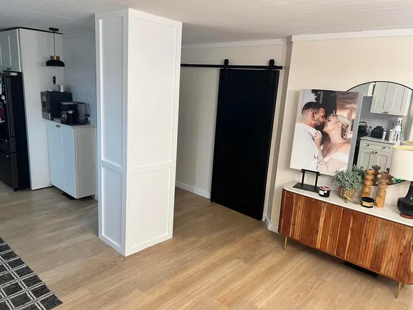a view of a kitchen with refrigerator and wooden floor