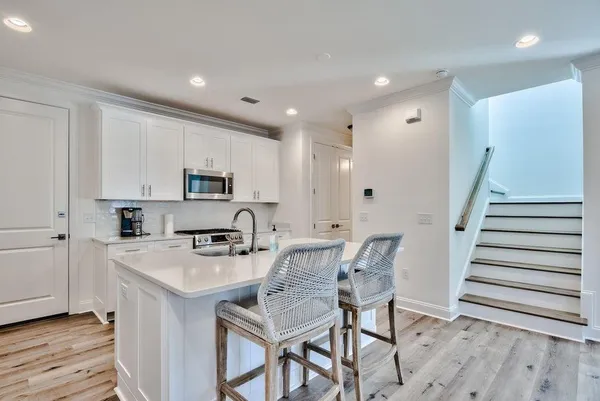 a kitchen with granite countertop a table chairs microwave and cabinets