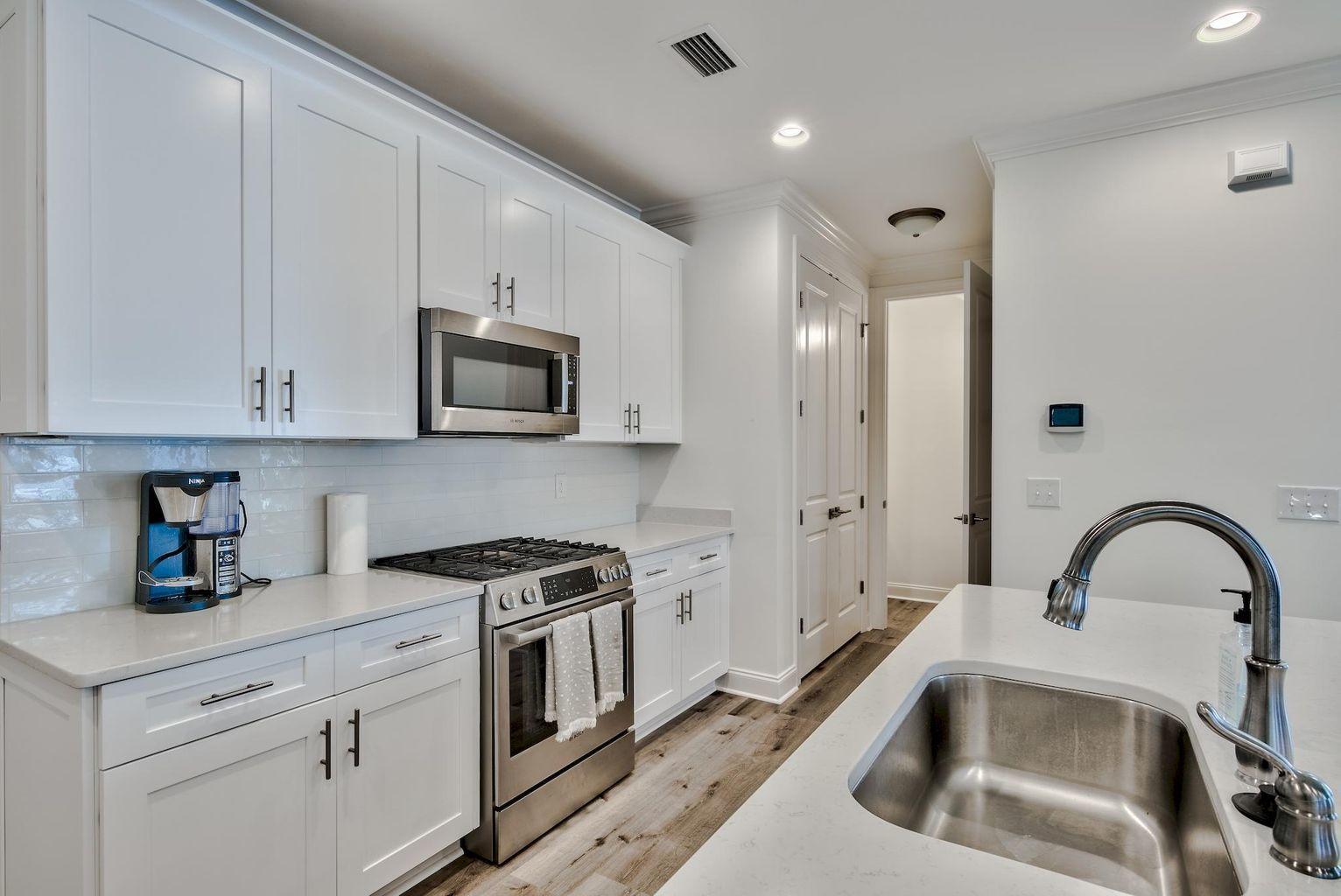 25 Cambium Ct Inlet Beach Inlet Beach, FL 32461 - Photo 7 of 29 a kitchen with white cabinets and stainless steel appliances