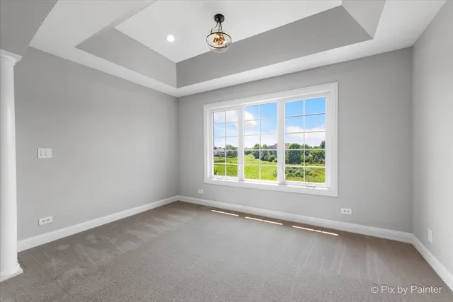 an empty room with ceiling fan and window