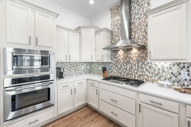 a kitchen with white cabinets and appliances