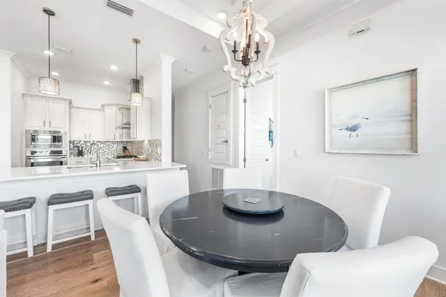 a kitchen with stainless steel appliances granite countertop a dining table and chairs