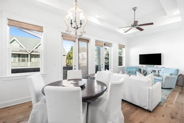 a living room with furniture a chandelier and a flat screen tv