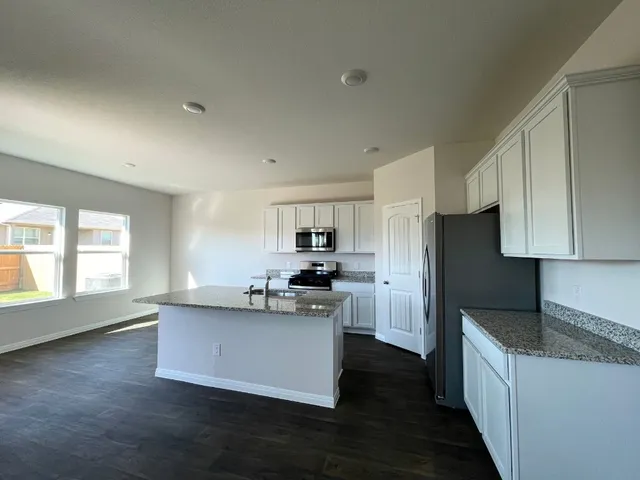 a kitchen with sink a microwave and cabinets