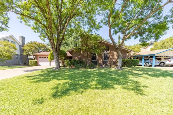 a view of a house with a big yard and large trees