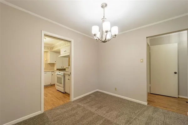 a view of a hallway with wooden floor and a kitchen