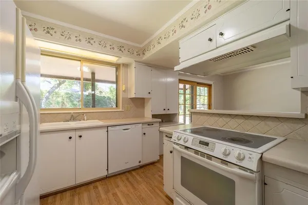 a kitchen with a stove a sink and a window