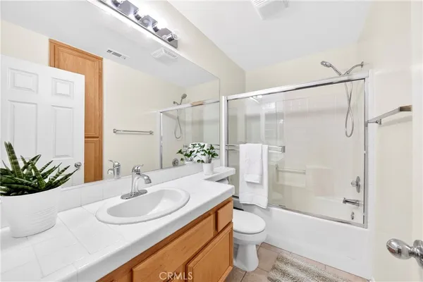 a bathroom with a granite countertop sink toilet a large mirror a shower and bathtub