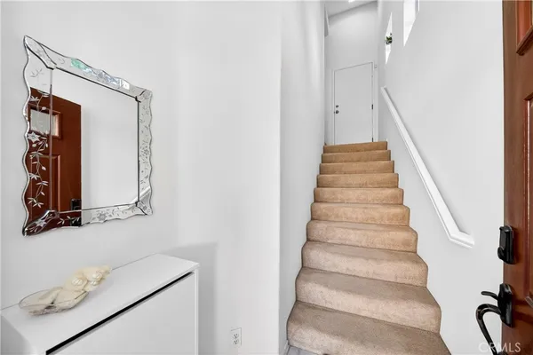 a view of staircase with white walls and a window