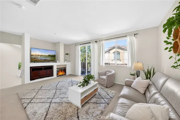 a living room with furniture a flat screen tv and a fireplace