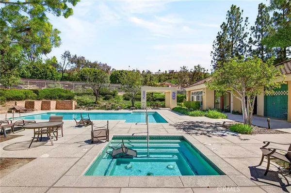 a view of a patio with couches and a table and chairs with wooden floor and fence