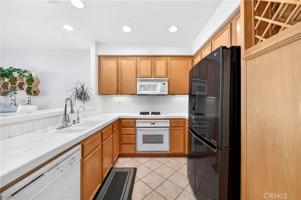 a kitchen with a sink a refrigerator and a stove top oven