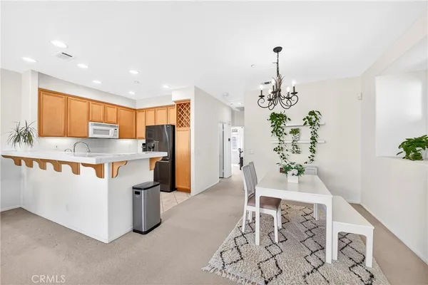 a kitchen with stainless steel appliances kitchen island granite countertop a table and chairs in it