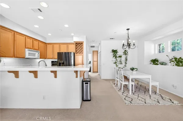 a white kitchen with stainless steel appliances granite countertop a refrigerator and a stove top oven