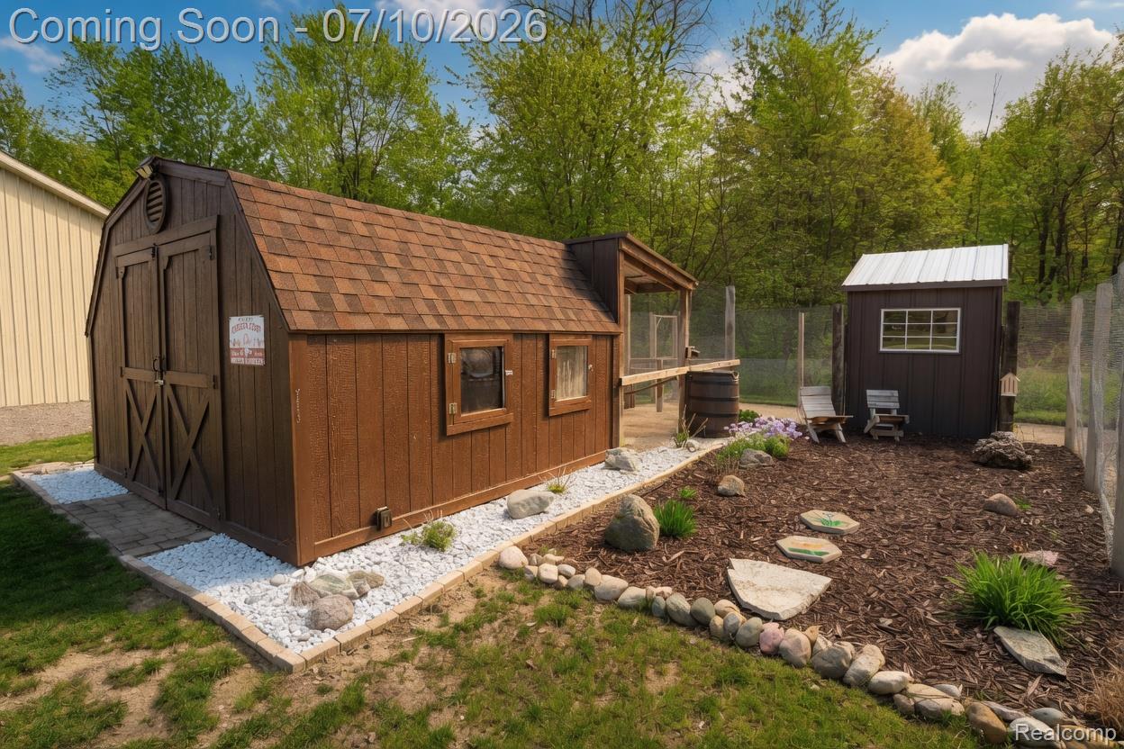 5278 Skelton Road Columbiaville, MI 48421 - Photo 11 of 64 Barn-style shed with asphalt shingle roof, double barn doors, and white gravel perimeter landscaping
