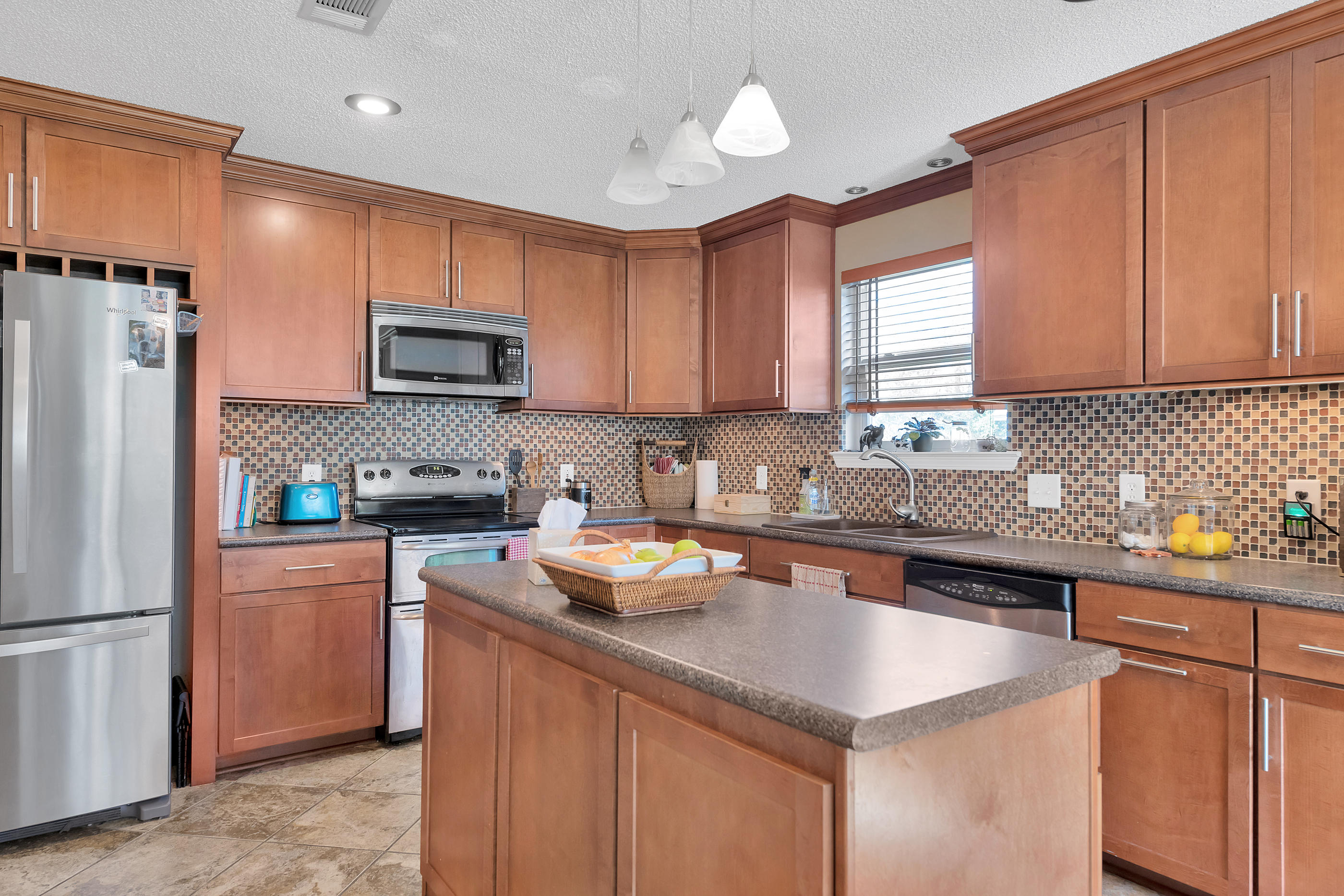 2734 Augustus Road Navarre, FL 32566 - Photo 13 of 23 a kitchen with stainless steel appliances granite countertop a sink stove and refrigerator