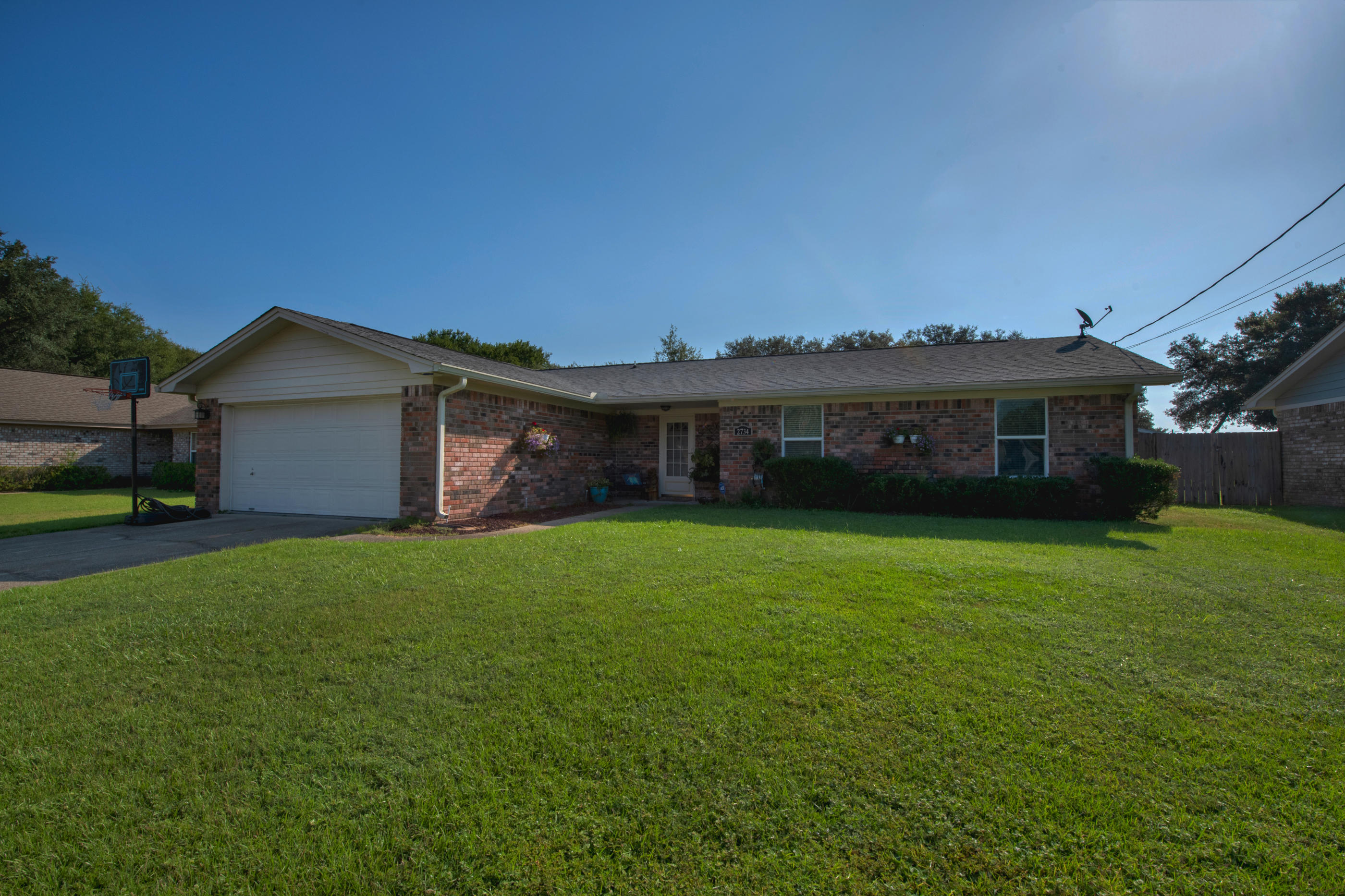 2734 Augustus Road Navarre, FL 32566 - Photo 23 of 23 a front view of house with a garden and deck