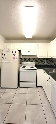 a kitchen with a stove a sink and a refrigerator