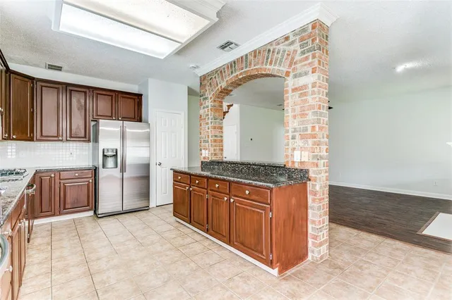 a kitchen with stainless steel appliances granite countertop a stove a sink and a refrigerator