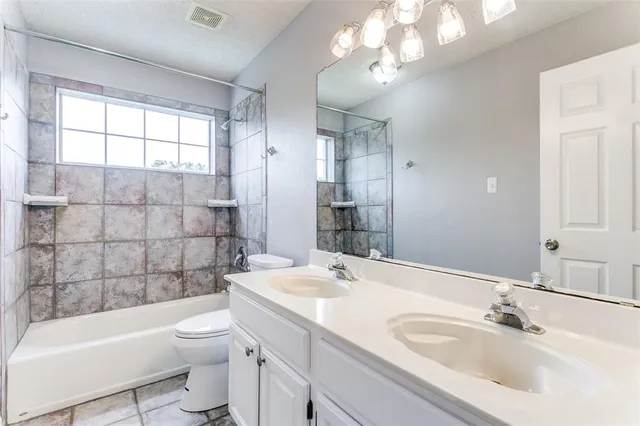 a bathroom with a sink a toilet a tub and shower