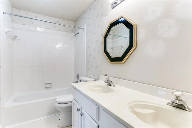 a bathroom with a sink a toilet and a mirror