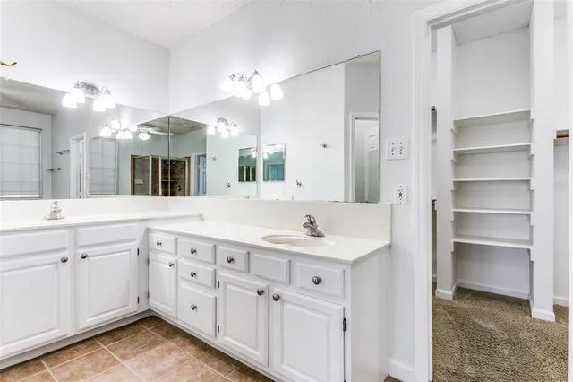 a spacious bathroom with a double vanity sink and a mirror