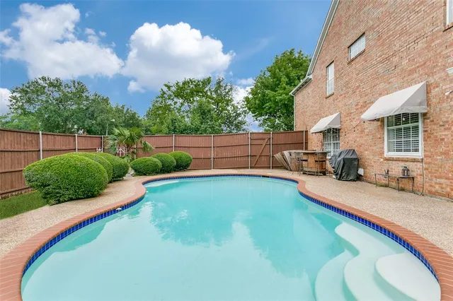 a swimming pool with outdoor seating and garden